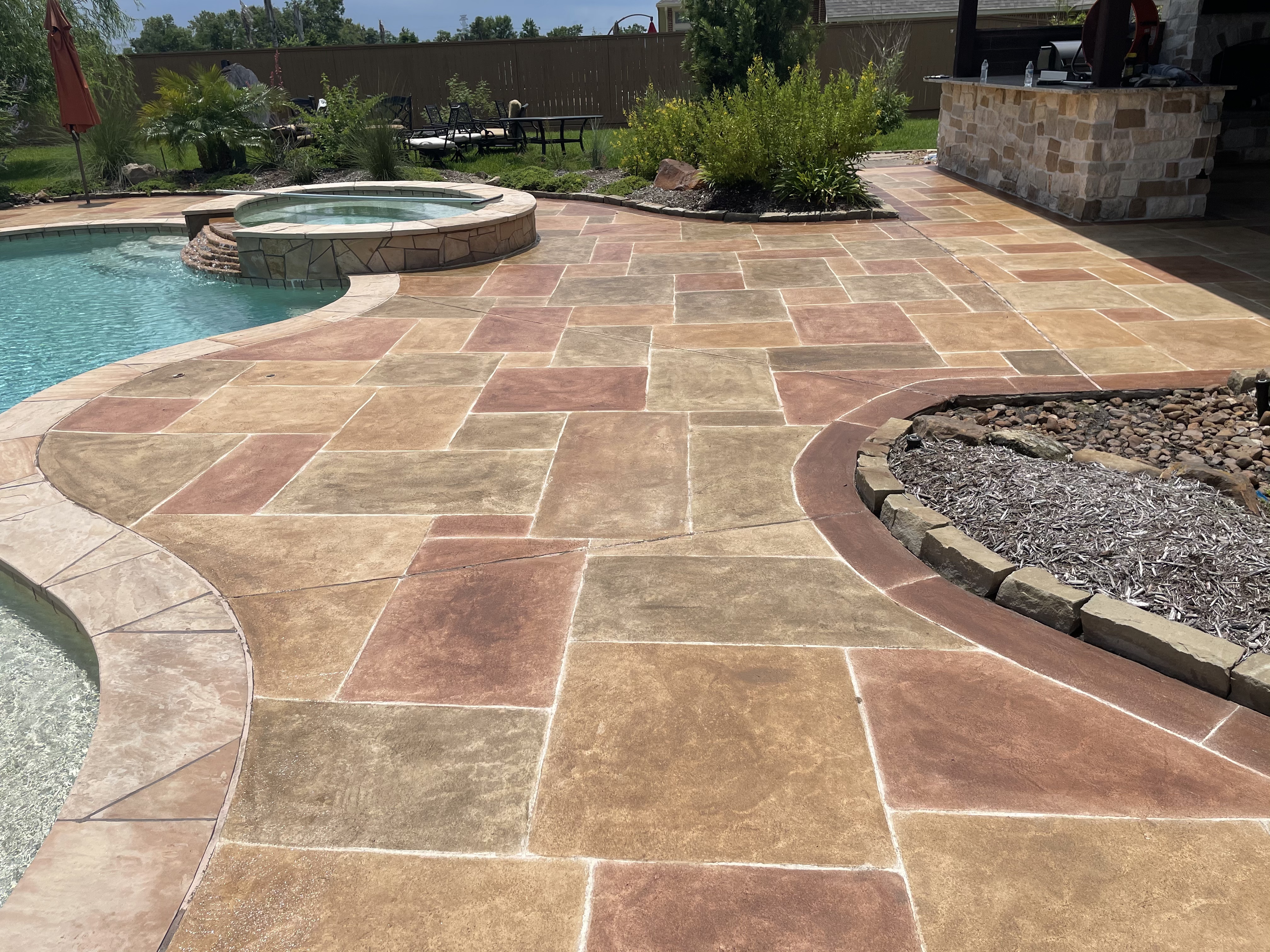 Decorative pool deck resurfacing with custom stone overlay in Houston